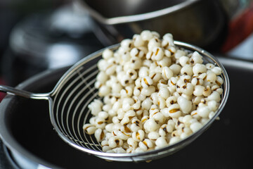 Hot Boiled Job’s Tears millet seed from boiler. White boiled Job’s Tears is highly nutritious cereal healthy fresh organic in salad dish.
