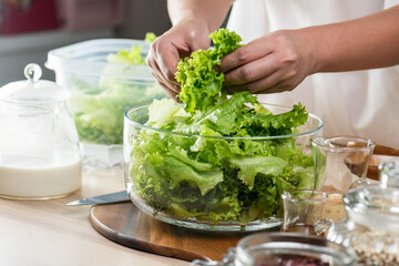 Hand chef mix fresh baby cos salad millet Crab Stick and pour salad dressing in wood blow. Organic Vegetables mix lunch with green salad In bowl. Breakfast fresh salad and clean vegetable