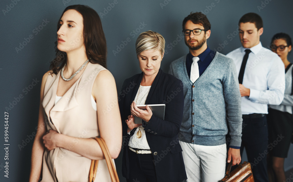 Poster waiting in line for a new opportunity. studio shot of a group of businesspeople waiting in line agai