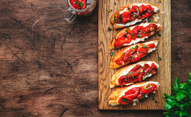 Wheat bruschetta with cream cheese and baked red paprika in olive oil with herbs served on rustic...