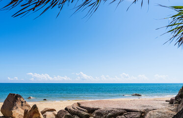 rock sand stone beach seaside with green leaves and blue sea sky summer landscape daylight well space rock stand for montage display product background