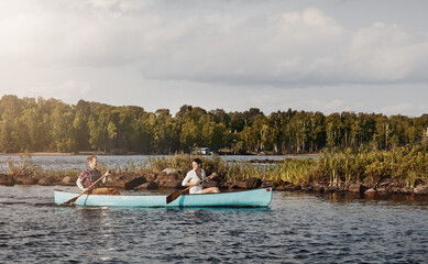 Fototapeta na wymiar Timeout with the one you love is worth it. a young couple going for a canoe ride on the lake.