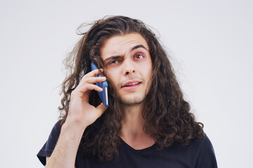 I think you have the wrong number. Studio shot of a young man using a mobile phone against a grey background.