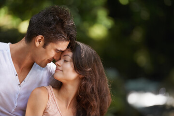 Nothing is more beautiful in nature than you. an affectionate young couple sharing a moment while hiking through the forest.