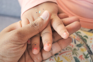 father holding hand of baby child, close up .