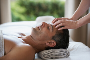 Fototapeta na wymiar Enjoying a head massage. a mature man enjoying a relaxing masasage.