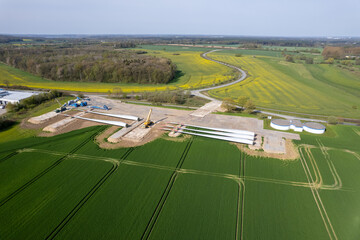 next to a road lie the rotor blades of a wind turbine