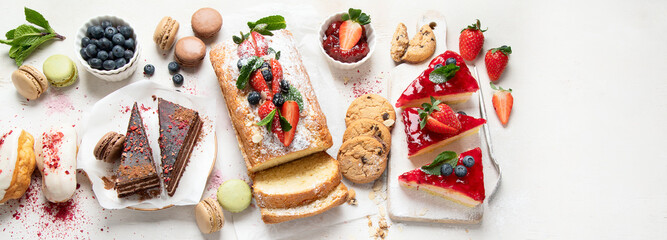 Table with various cookies, cakes and fruits. Delicious dessert table.