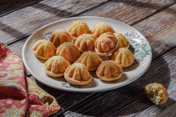 Malaysian traditional sweet sponge cake called Kuih Bahulu or Bolu on a plate