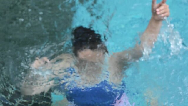 Asian woman drowning in swimming pool area