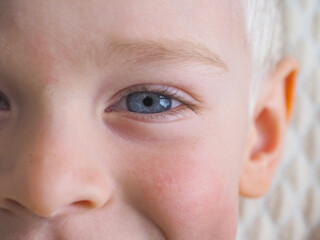 Close-up of a child's face with blue eyes. Selective focus.