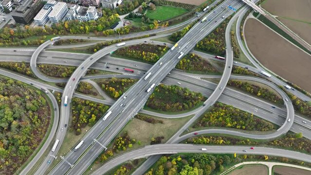 Aerial drone view of a multi-level highway intersection with moving cars near the city of Stuttgart, Germany. Trucks move along a multi-level road junction. The concept of the urban.