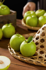 Green apples in a basket, fresh apples (scene inside the orchard)