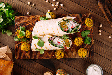 Portion of vegetarian falafel wrap roll on serving board