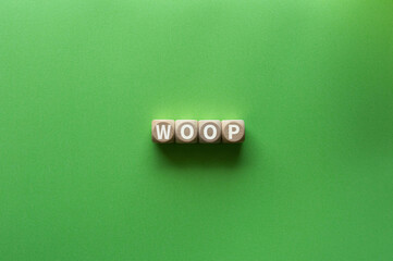 There is wood cube with the word WOOP. It is an abbreviation for Wish, Outcome, Obstacle, Plan as eye-catching image.