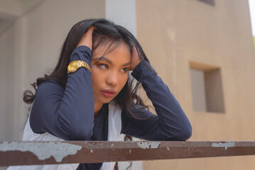 A close-up picture of a pretty young lady wearing a cardigan and a navy blue long sleeves top with...