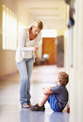 Teacher, school and scolding child student for bad behaviour, problem or learning lesson. Frustrated woman pointing to punish boy for discipline, pedagogy or fail in education building hallway