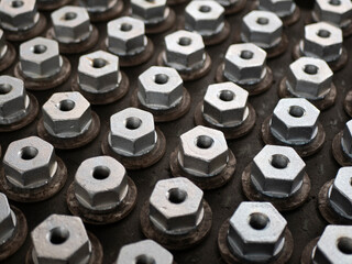 Metal hex bolts in the production, top view. Fasteners manufacturing, industrial concept