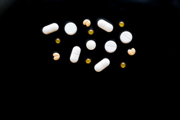 tablets and pills in background.assorted pills and capsules in medicine. drugs of various kinds and different colors. Medicine on black background.Copy space