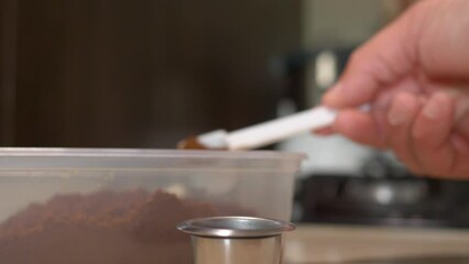Extreme closeup shot loading Reusable Coffee capsule with coffee powder in Slow motion