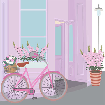 Pink bicycle with flowers in a basket in the back seat, standing at the door of an old pink building, flowers in a flower box and flower pot and a lantern. World Bicycle Day. Postcard, background.
