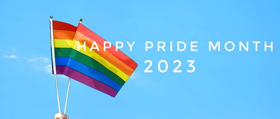 'Happy Pride Month 2023' on blurred rainbow flag raising background, concept for LGBT people...