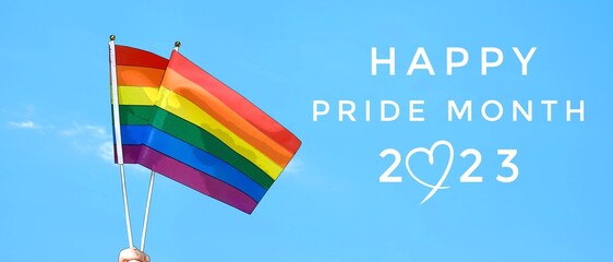 'Happy Pride Month 2023' on blurred rainbow flag raising background, concept for LGBT people...
