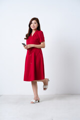 Portrait of a beautiful, charming lady wearing a red dress on a white background