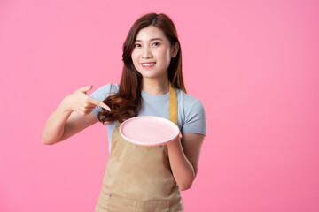 portrait of asian girl wearing apron on pink background