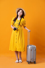 portrait of beautiful asian girl wearing yellow dress on orange background