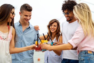 Friends at the beach drinking cocktails having fun on summer vacation