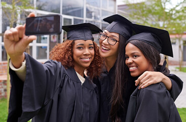 Education, women celebrating graduation with selfie and group at the ceremony outside on campus....