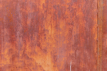 detail of the texture of an antique rusty metallic door painted red
