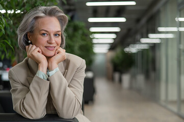 Attractive mature woman sitting on sofa in lobby.