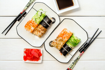 Several sushi on a white plate standing on a white background
