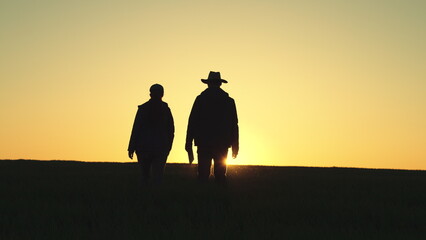 Farmer silhouette. two partners sunset shake hands with each other. business concept. tablet box. team farmers negotiate deal. group workers. Wheat field. smart farm tablet. Business deal farm.
