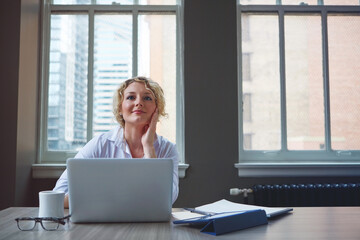 When work is fulfilling success is inevitable. a businesswoman using a laptop in an office.