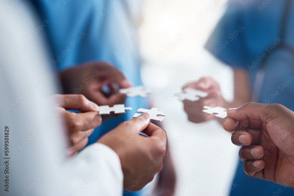 Poster teamwork is like putting a puzzle together. a group of unrecognizable doctors each holding a puzzle 