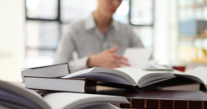 Student woman with many books preparing for exam. Studying law from scratch on your own