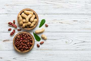 Fresh healthy peanuts in bowl on colored table background. Top view Healthy eating bertholletia concept. Super foods