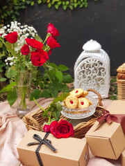 Gift box and flowers in hands against spring background. Family holiday concept. Mothers day