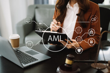AML Anti Money Laundering Financial Bank Business Concept. judge in a courtroom using laptop and tablet with AML anti money laundering icon on virtual  screen. ..