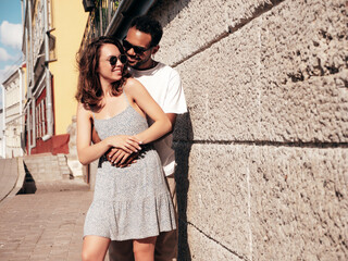 Smiling beautiful woman and her handsome boyfriend. Woman in casual summer clothes. Happy cheerful family. Female having fun. Sexy couple posing in the street at sunny day. In sunglasses