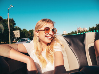 Portrait of two young beautiful and smiling hipster female in convertible car. Sexy carefree women...