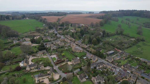 Bourton on the Hill Cotswold village UK high angle panning drone aerial view