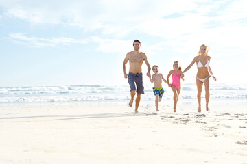 Family makes the fun. a happy young family running on the beach together.