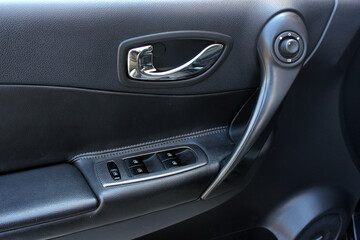 Obraz na płótnie Canvas Window control buttons in modern car. Car window control panel. Door handle with power window control. Close up old car interior. 