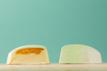Close up of homemade brown chocolate bonbon slice. Assortment of hand painted candies. Candy cut in a half. Mockup with a copy space. Macro shot of  chocolatier products on turquoise background