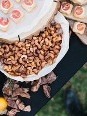 Offsite open-air buffet. Canape caprese, cashew nuts in caramel.