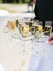 The waiter carries glasses of champagne. Bubbles of champagne in a glass.